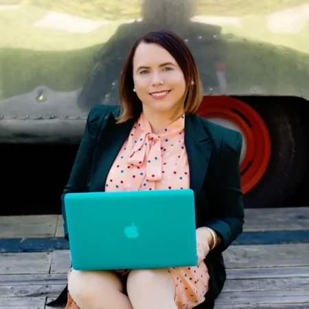 Vanessa, author of Brite & Bubbly, sitting with laptop and smiling.